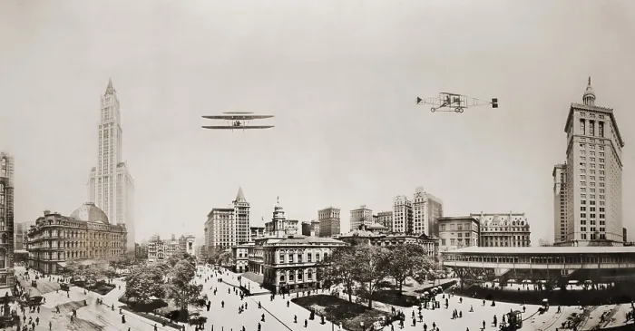 Framed Print : Wide angle panorama with two airplanes in flight over downtown Manhattan. At left are the Custom House and Woolworth Building in center is City Hall and at left Park Place Framed Print : Wide angle panorama with two airplanes in flight over downtown Manhattan. At left are the Custom House and Woolworth Building in center is City Hall and at left Park Place
