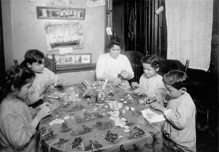 Framed Print : Woman, two boys, and two girls sitting at a table, making artificial flowers, New York City, photograph by Lewis Wickes Hine, March, 1922