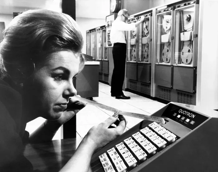 Framed Print : Woman holds tape with the latest stock prices printed by the Quotron II Framed Print : Woman holds tape with the latest stock prices printed by the Quotron II