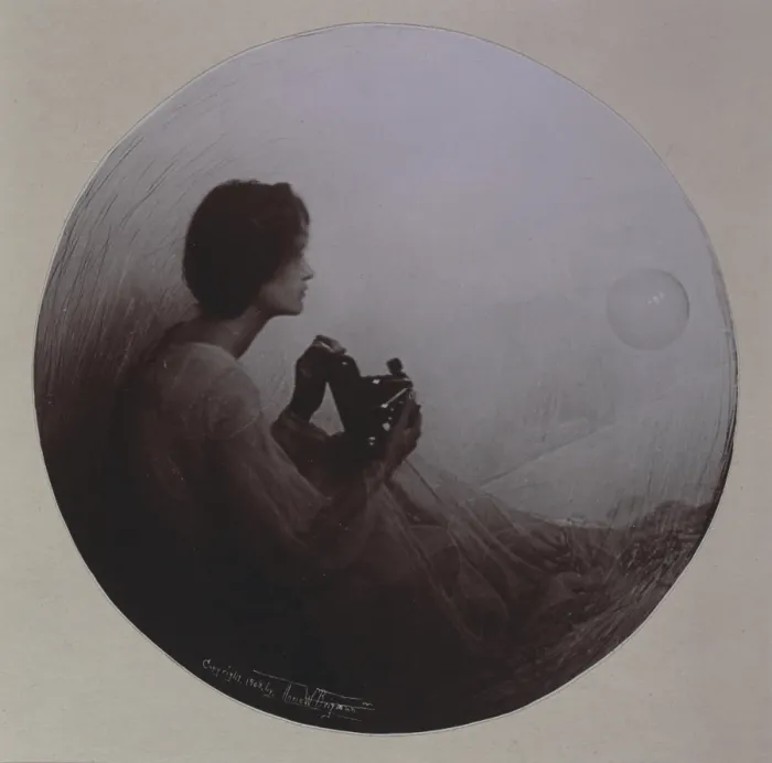 Framed Print : Woman seated with Kodak camera, in roundel, photograph by Anne Brigman, circa 1908