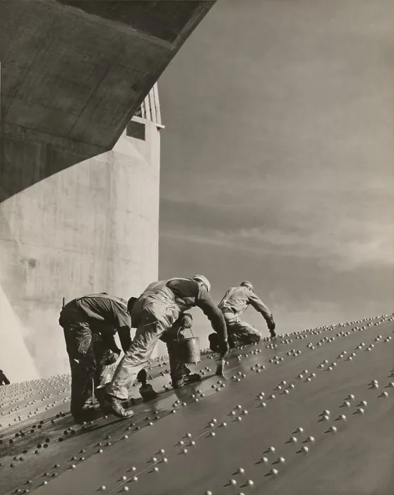 Framed Print : Three workers painting on a slanted wall of riveted-steel plates on the Hoover Dam spillway. Ca. 1940