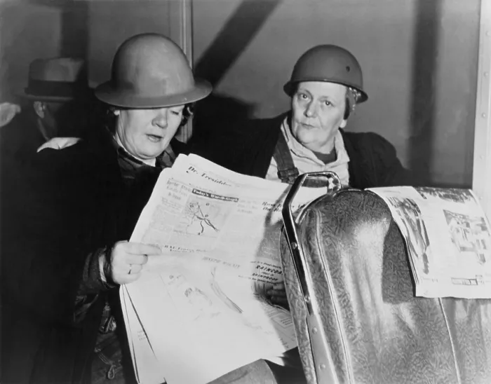 Framed Print : After working all night, two helmeted women shipyard workers read the newspaper on the bus home. Ca. 1940-45. World War 2. (BSLOC_2014_10_216)