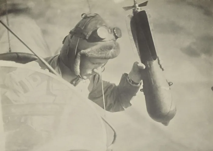 Framed Print : World War 1 flyer holding a bomb in his hand, waiting to release it on target. By Italian photographer Fedele Azari, 1914-1918 (BSLOC_2017_1_23)