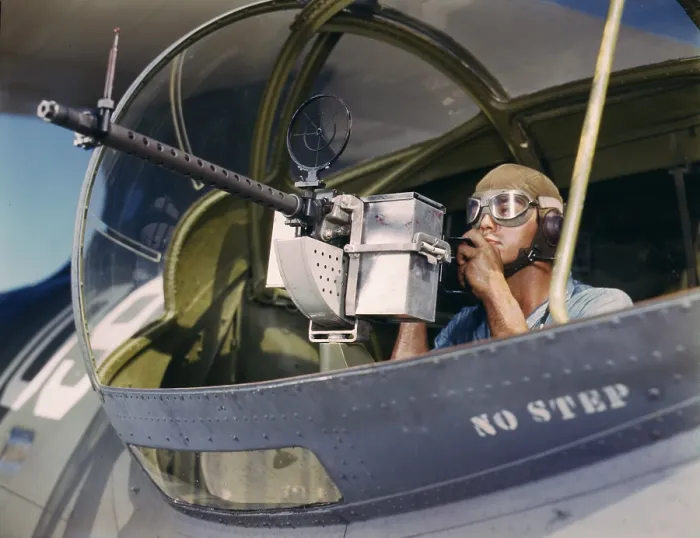 Framed Print : World War II, Jesse Rhodes Waller, A.O.M. third class, tries out a 30-calibre machine gun he has just installed on a Navy plane, Naval Air Base, photograph by Howard R