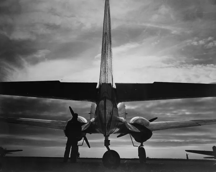Framed Print : World War II, soldier beside WWII airplane at sunrise, circa early 1940s