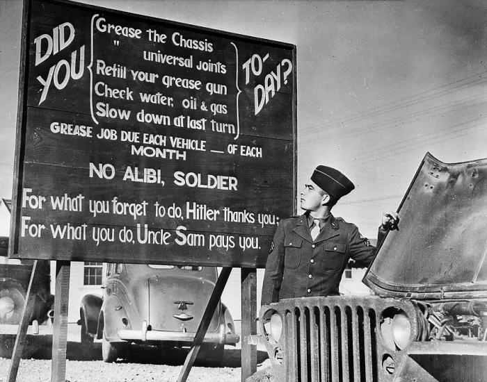 Framed Print : World War II, U.S. soldier at base in front of patriotic message, circa 1940-1946 Framed Print : World War II, U.S. soldier at base in front of patriotic message, circa 1940-1946