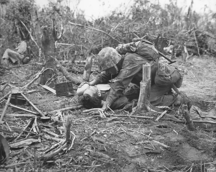 Framed Print : A wounded U.S. Marine takes is given water while waiting for stretcher-bearers to come for him. Peleliu Island. Sept.-Nov. 1944. World War 2, Pacific Ocean. (BSLOC_2013_13_30)