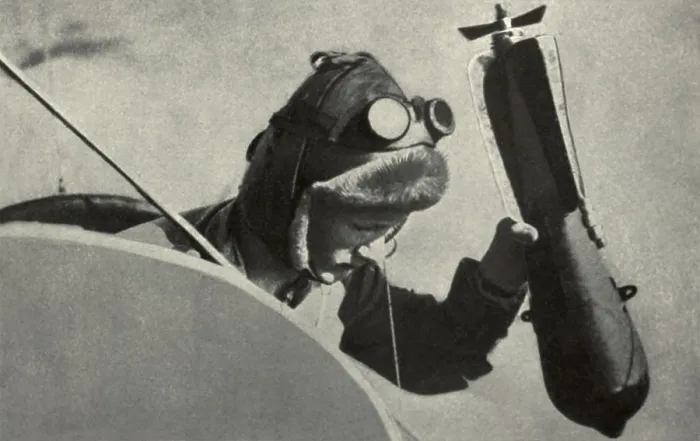 Framed Print : WW1 pilot dropping a handheld bombing from his plane. 1914-1918. (BSLOC_2012_4_71)
