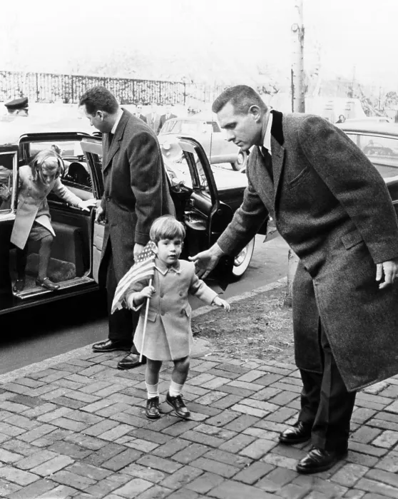 Framed Print : Young John and Caroline Kennedy with Secret Service men as they enter their temporary home after leaving the White House