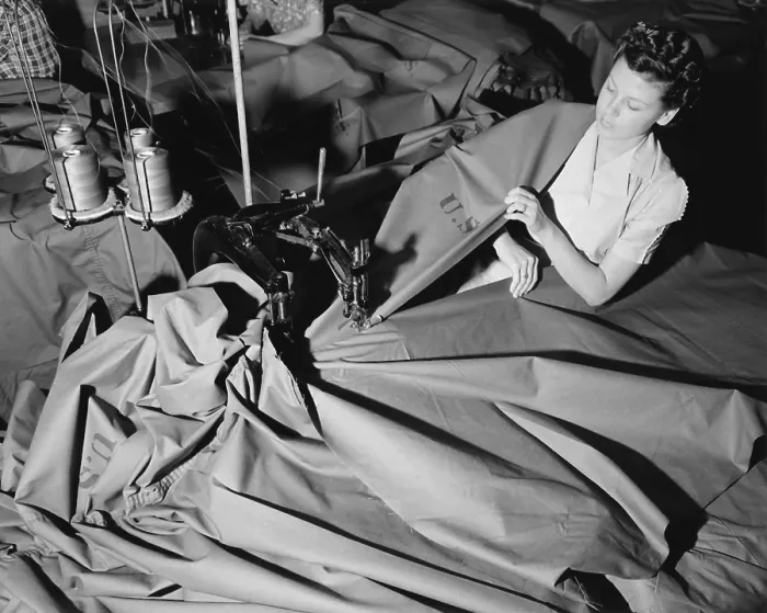 Framed Print : A young woman sews pup tents for the U.S. Army. At the Langdon Tent & Awning Company, a two-needle machine joins widths of cloth to form the tent. June 1941
