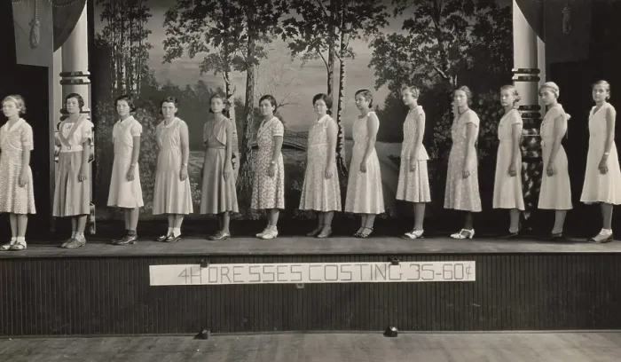 Framed Print : Young women on stage modeling dresses at a 4-H Club event, 1925-1930. They are modeling dresses the made for the cost of 35-60 cents ($4.85 to $8.30 in 2016) (BSLOC_2016_8_107) Framed Print : Young women on stage modeling dresses at a 4-H Club event, 1925-1930. They are modeling dresses the made for the cost of 35-60 cents ($4.85 to $8.30 in 2016) (BSLOC_2016_8_107)