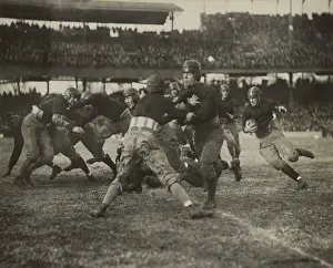 Players Prints: 1920s football action. Thousands of spectators watch from double decker stadium seats