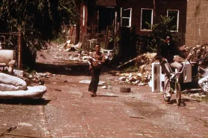 Bicycle Prints: 1970s America. Two young boys pass through a trash-strewn alley of Chicago