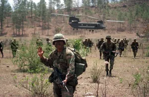 Honduras Prints: An 82nd Airborne Division soldier signals to his platoon as they advance across a field in Honduras after being