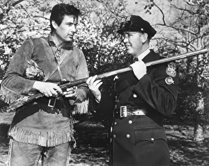 Fess Prints: Actor Fess Parker in the frontier costume of Davy Crocket with a White House policeman