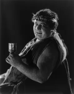 Silent Prints: Actor from Mack Sennett comedy film in Roman toga seated holding wine glass. Ca. 1920