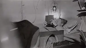 Travel Prints: Admiral Richard Byrd reading by lantern light in his basecamp bunk at Little America