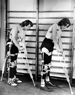 Physical Therapy Prints: Two adult women polio victims with leg braces adjust their crutches