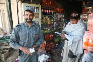 Candid Occupational Portrait Prints: Afghan National Police officer shops at a store in Now Zad Helmand province Afghanistan