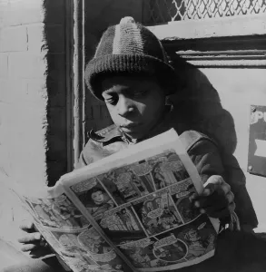 Comics Prints: African American boy reading a comic book