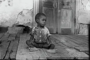 Negro Prints: African American child on a dilapidated porch