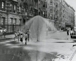Street Scenes Prints: African American children playing in water sprayed from a sprinkler in South Harlem