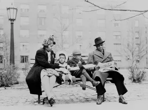 Toys Prints: An African American family on a park bench in an urban neighborhood. Ca. 1942