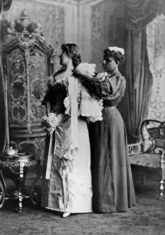 Wealthy Prints: African American ladys maid helps a wealthy woman get dressed in luxurious evening gown