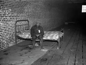 Sitting On Bed Prints: African American man in infirmary after flood