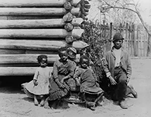 Brothers Prints: African American teenager and three children posed by log building