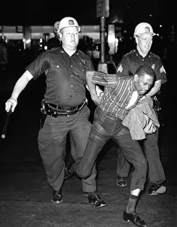 Urban Poverty Prints: An African American who police accused of wielding a knife is taken into police custody