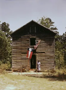 Jack Delano Prints: African American woman standing by building with Georgia state and United States flags