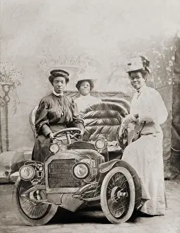 Girlfriends Prints: Three African-American women posed with studio prop automobile, c. 1905-1915
