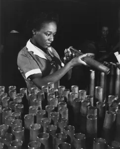 Munitions Prints: African American young woman inspecting the end of 40mm artillery cartridge case at Frankfort Arsenal