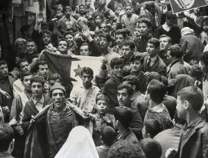 Algeria Prints: Algeria (1959). Young Algerians unfurl the Algerian flat during a cease-fire in the Kasbah of Algiers