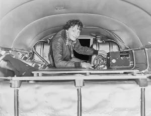 Amelia Prints: Amelia Earhart (1897-1937), checking equipment on her airplane. Ca. 1937
