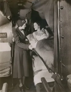 Beds Prints: American Airlines stewardess with a passenger in a sleeping berth on a commercial flight in the 1930s
