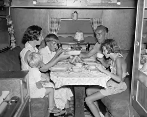 Dining Prints: American family dining at the table in their Trailer Camper. June 4, 1937