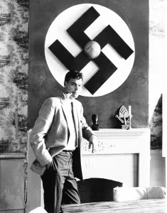Segregationists Prints: American Nazi George Lincoln Rockwell stands by a huge swastika on the wall over the fireplace