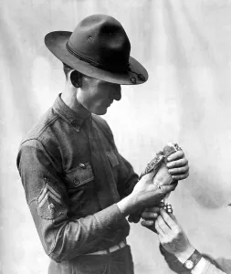 Images Dated 3rd December 2012: American soldier attaching a message to a Signal Corps carrier pigeon