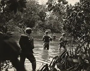 Jungle Warfare Prints: American soldiers wading through water in on an island in the New Georgia Group of the Solomon Islands as part of