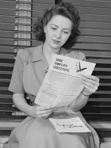 Rationing Prints: American woman reads a government brochure on titled Save, Simplify, Substitute