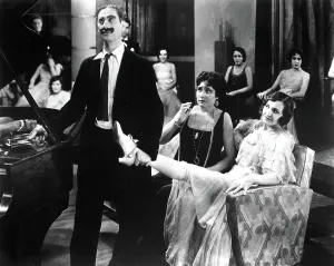 ANIMAL CRACKERS, Groucho Marx, Margaret Dumont, 1930, holding her leg