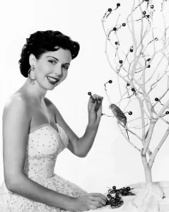Christmas Tree Prints: Ann Miller, decorating her Christmas tree, ca. early 1950s