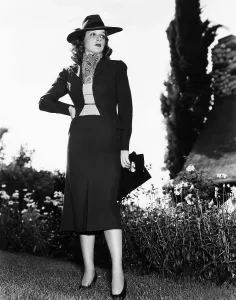 Vest Prints: Ann Sheridan in tile red flannel suit designed by Howard Shoup with broad brimmed felt hat