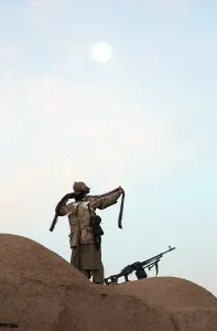 Helmand Province Prints: An Anti-Taliban fighter wraps a bandolier of Kalashnikov machine gun ammunition around his body