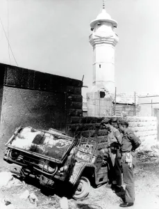 Inspecting Prints: Arab-Israeli War, Royalist soldiers inspecting the burned hulk of a Commando vehichle outside guerrilla headquarters