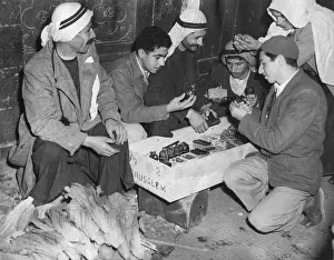 Israel Prints: Arab Palestinians examine weapons in a Jerusalem market
