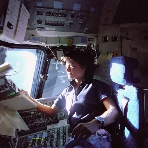 June Prints: Astronaut Sally Ride monitors control panels from the pilot's chair on the flight deck of the Space Shuttle