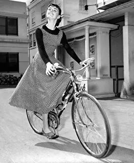 : AUDREY HEPBURN bicycles to soundstage where she is filming SABRINA, 1954